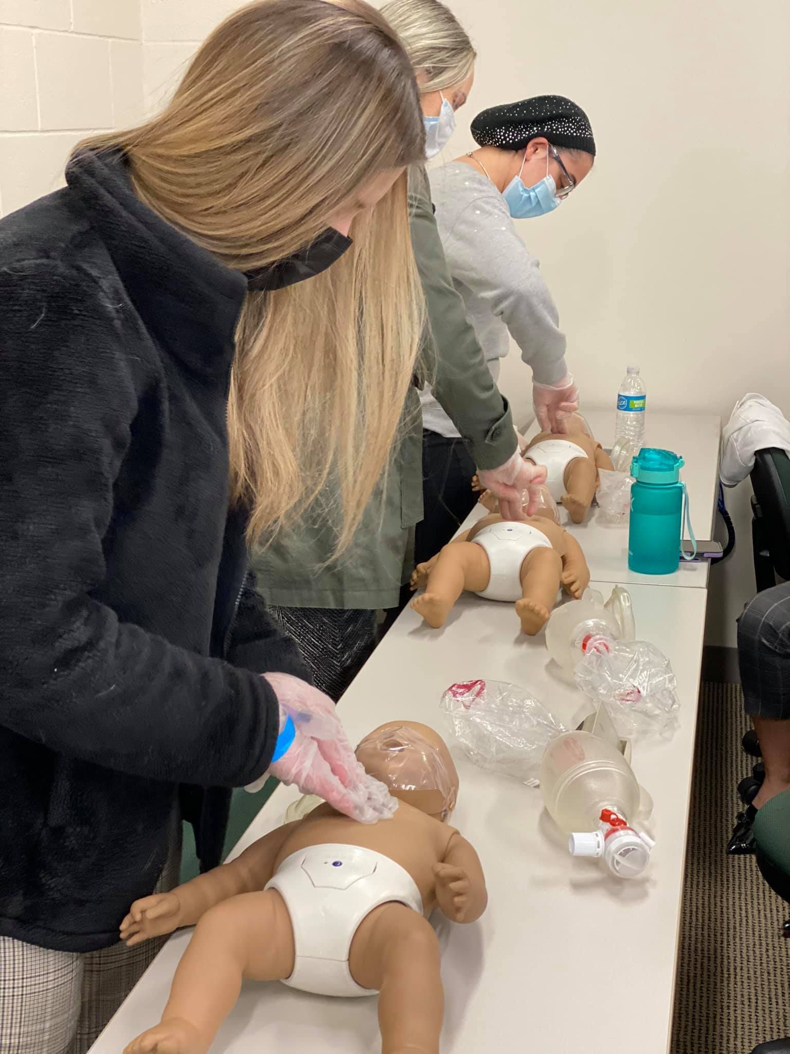 People practicing infant CPR on manikins during a Tri-State Training class