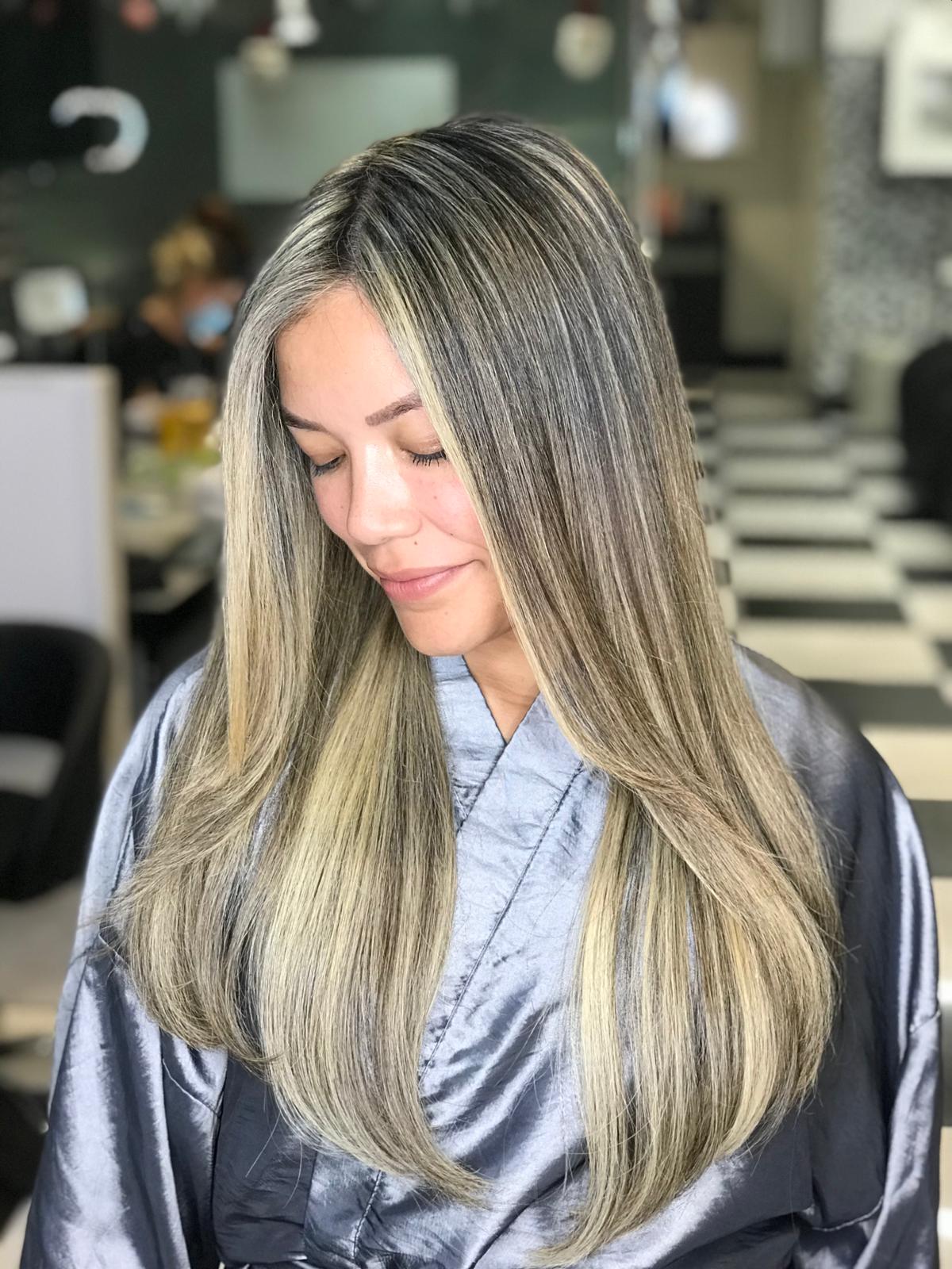A woman with long blonde hair is wearing a gray robe.