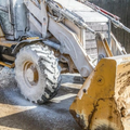 Yellow loader with muddy tire on a dirt construction site