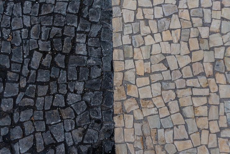 Dark and light stone paving blocks arranged in two contrasting sections.