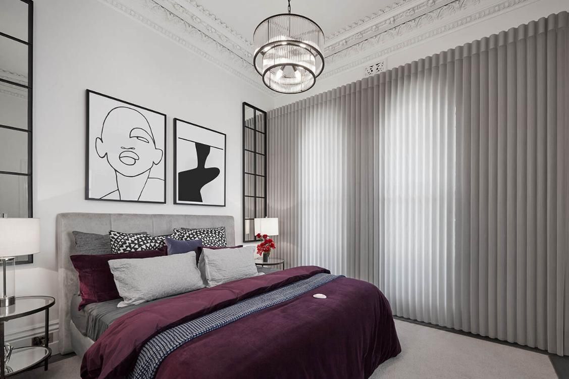 A Bedroom With a Bed, Nightstand, Lamps and a Chandelier — Whitsunday Vogue Interiors in Cannonvale, QLD