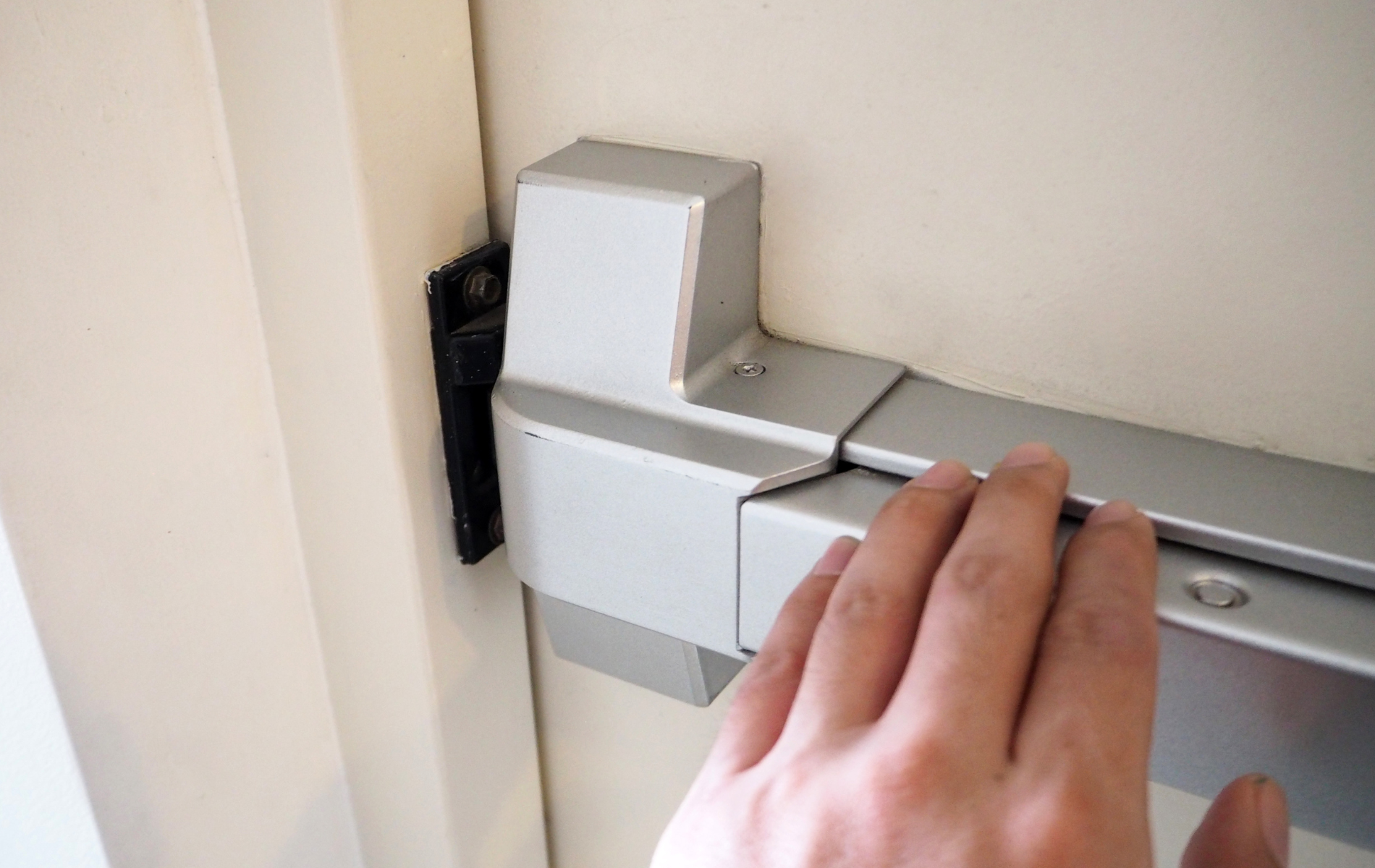 A person is opening a door with their hand.