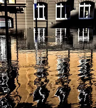 A reflection of a building in a puddle of water