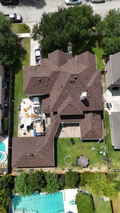 Roofer repairing a shingle leak on a residential roof.