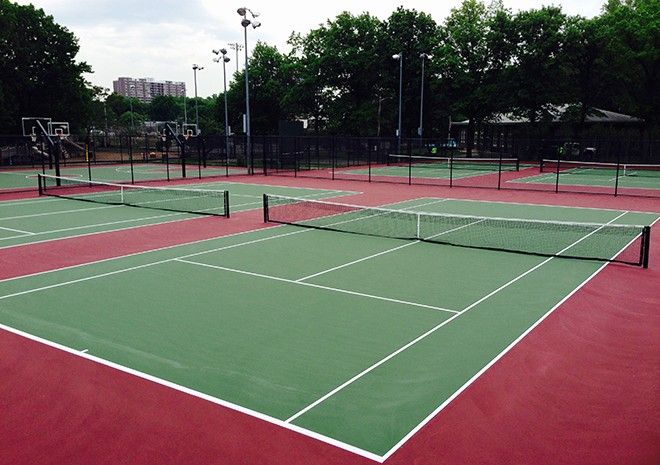 A couple of tennis courts with trees in the background