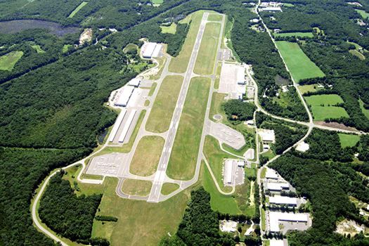 An aerial view of an airport surrounded by trees and fields.