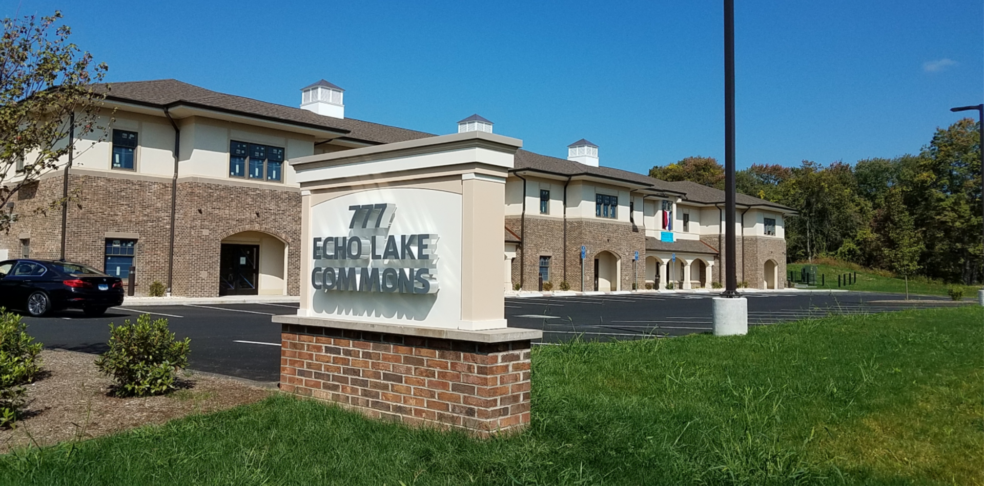 A large building with a sign in front of it that says road lake commons.