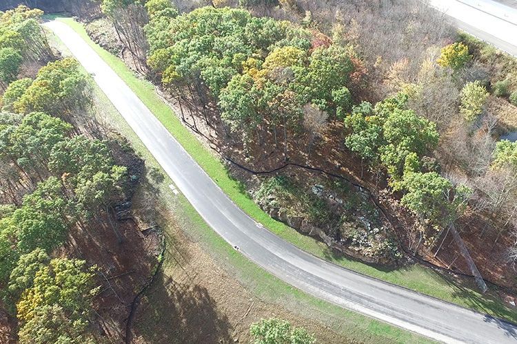 An aerial view of a curvy road surrounded by trees.