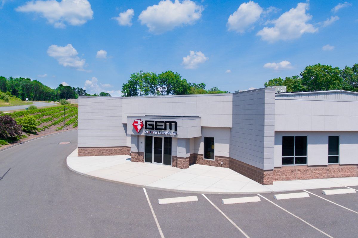 An aerial view of a gem building with a parking lot in front of it