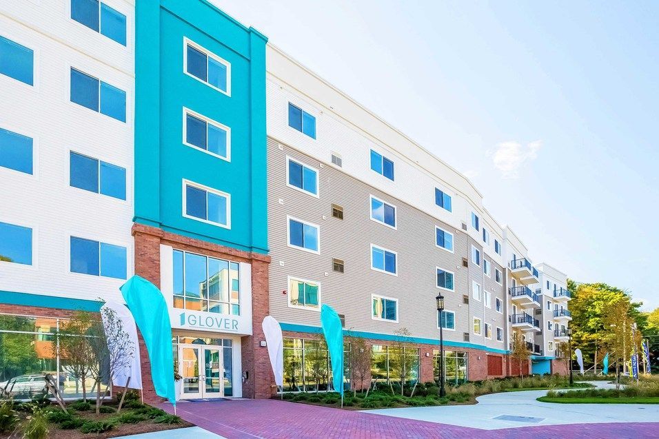 A large blue and white building with a purple walkway in front of it.