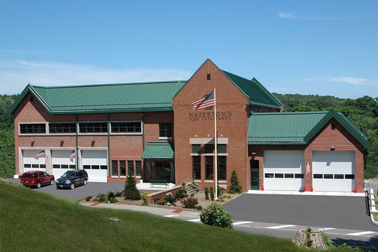 A large brick building with a green roof and a flag on top