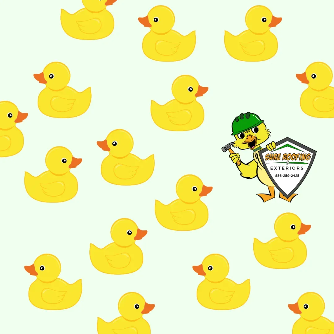 Yellow rubber ducks scattered on a pale background, with a small cartoon mascot holding a shield on the right.