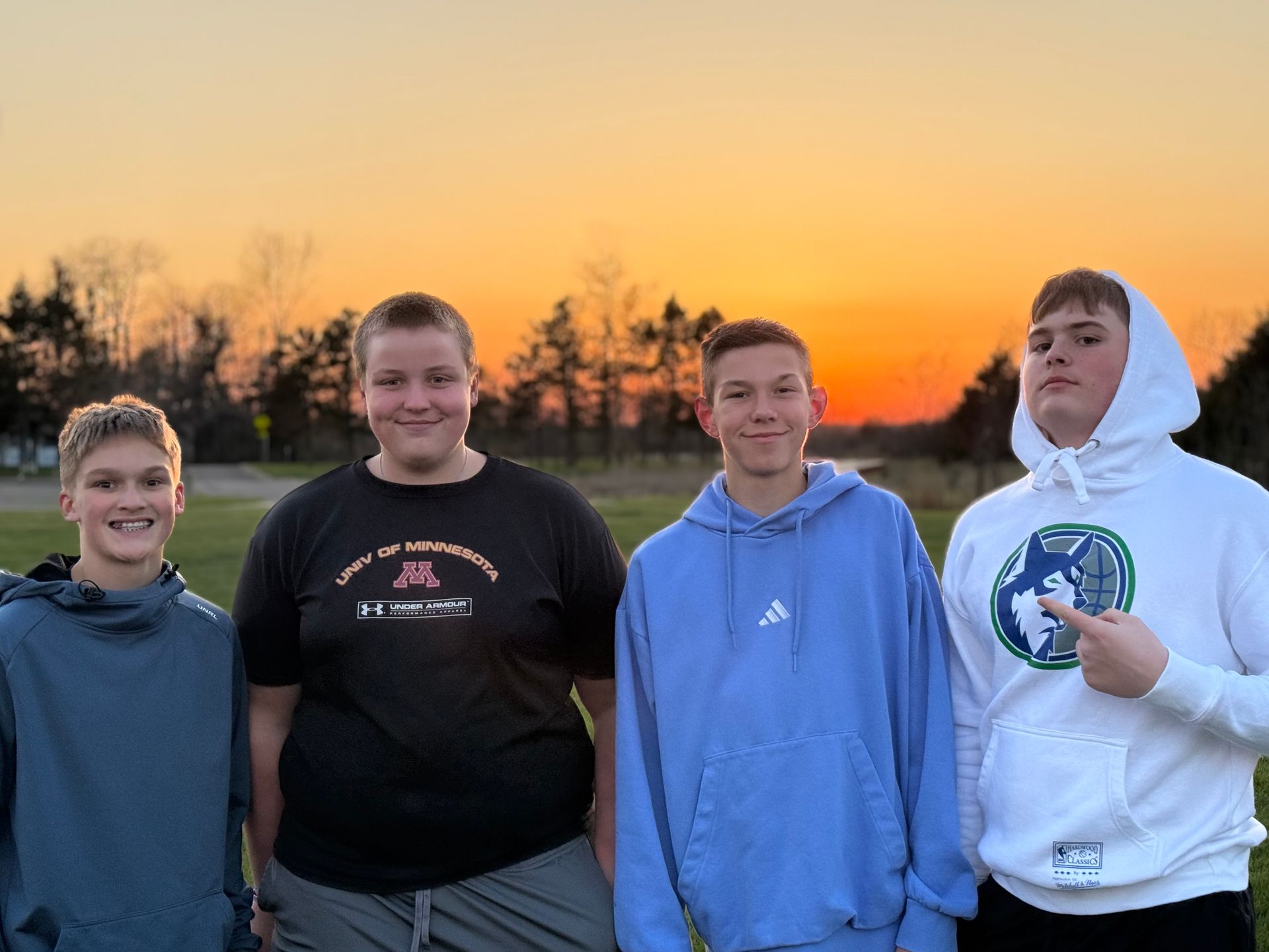 A group of young men are standing next to each other on a path in the woods.