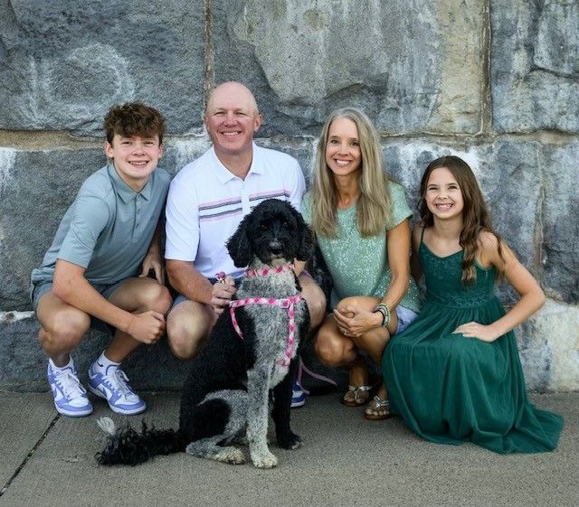 A family posing for a picture with their dog