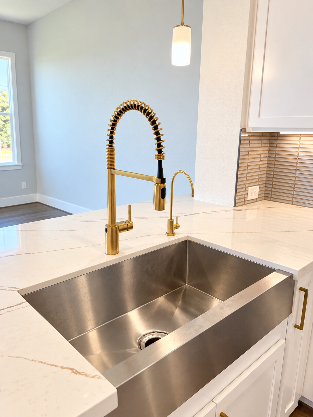 Person pouring water into a glass over a kitchen sink