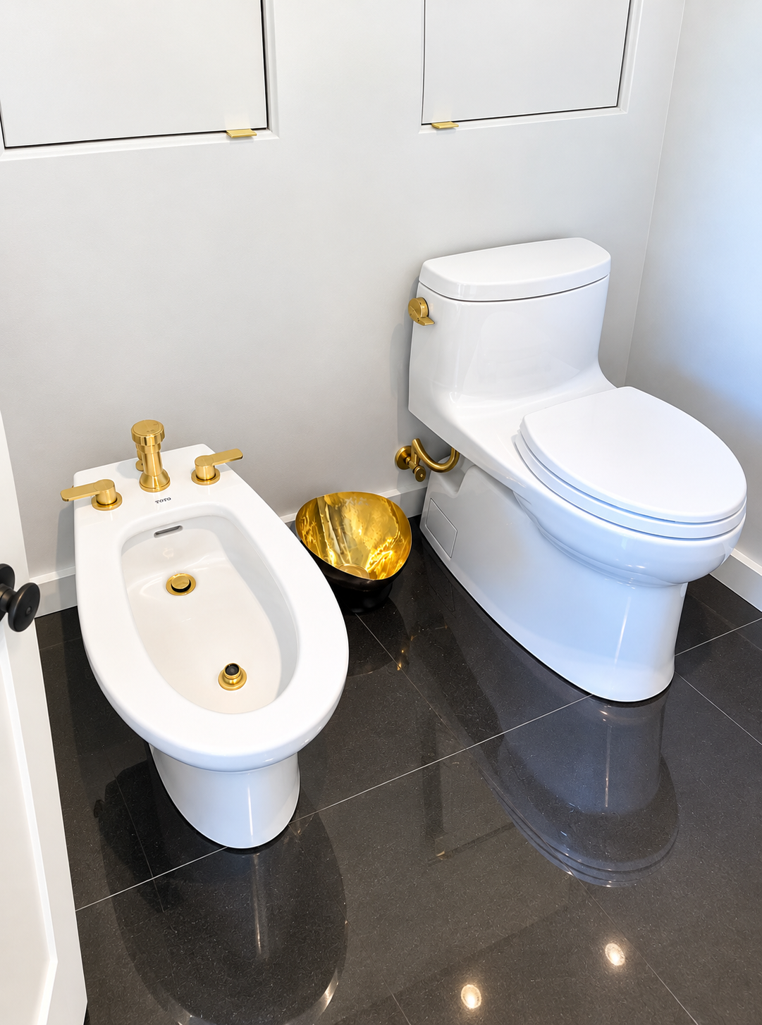 Hand turning a toilet flush handle on a white toilet in a bathroom