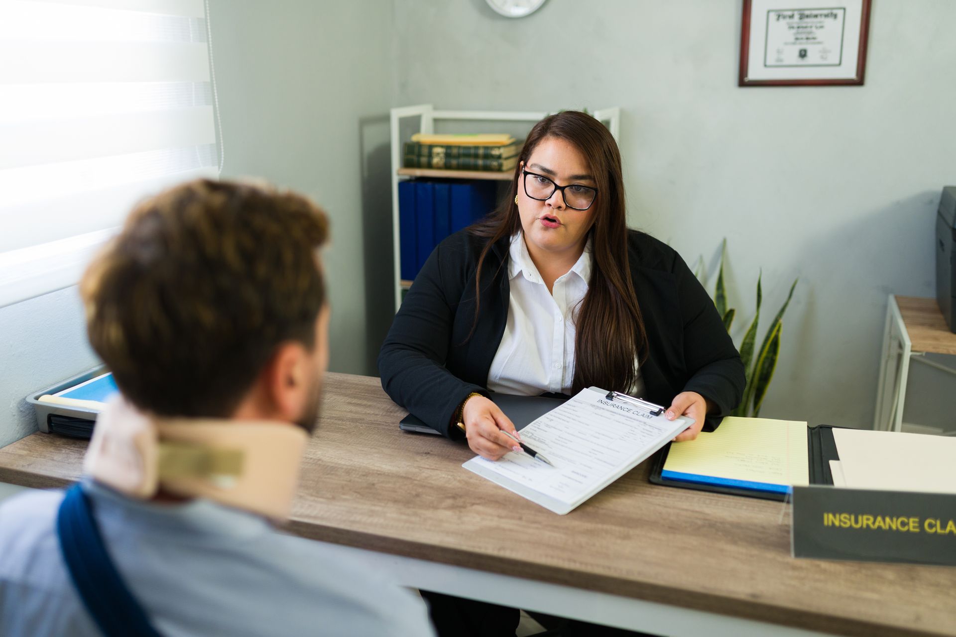 A female lawyer is discussing an insurance claim with an injured client. A female lawyer is discussing an insurance claim with an injured client.
