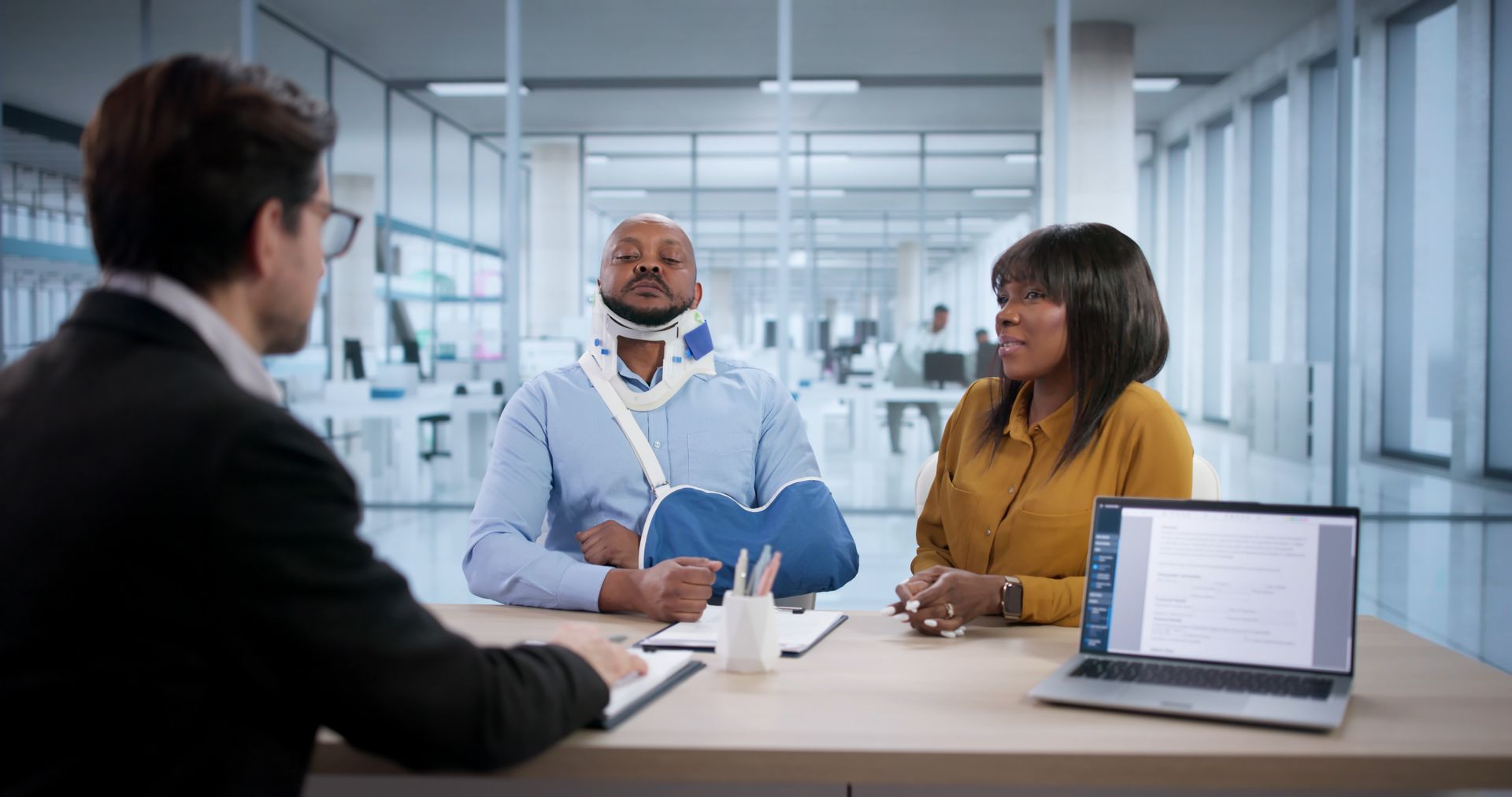 An injured worker with a brace talks to a personal injury lawyer. An injured worker with a brace talks to a personal injury lawyer.