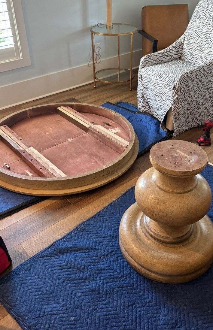 Round wooden table parts laid out on a blue blanket.