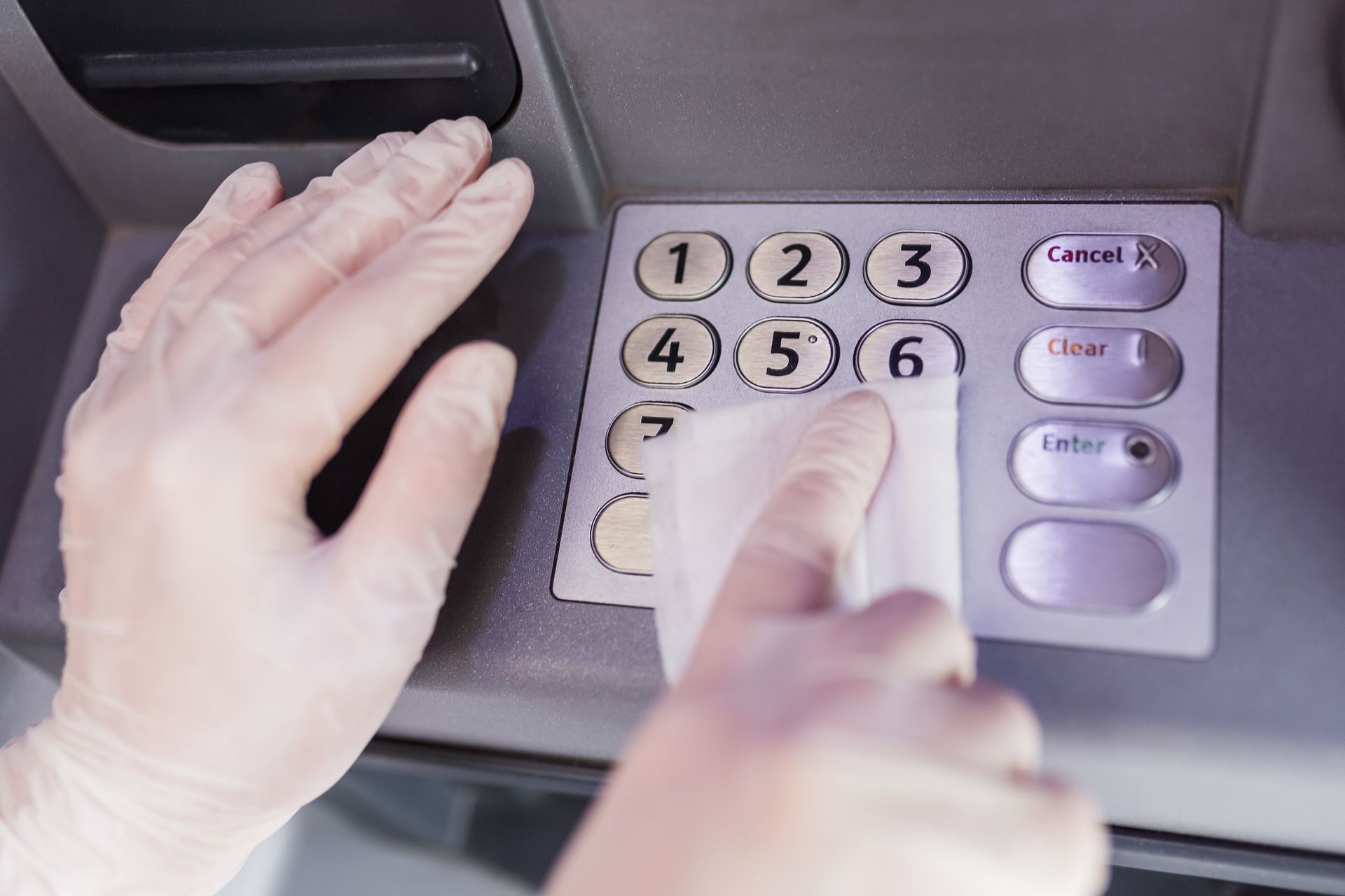 A person is using an atm machine to swipe a credit card