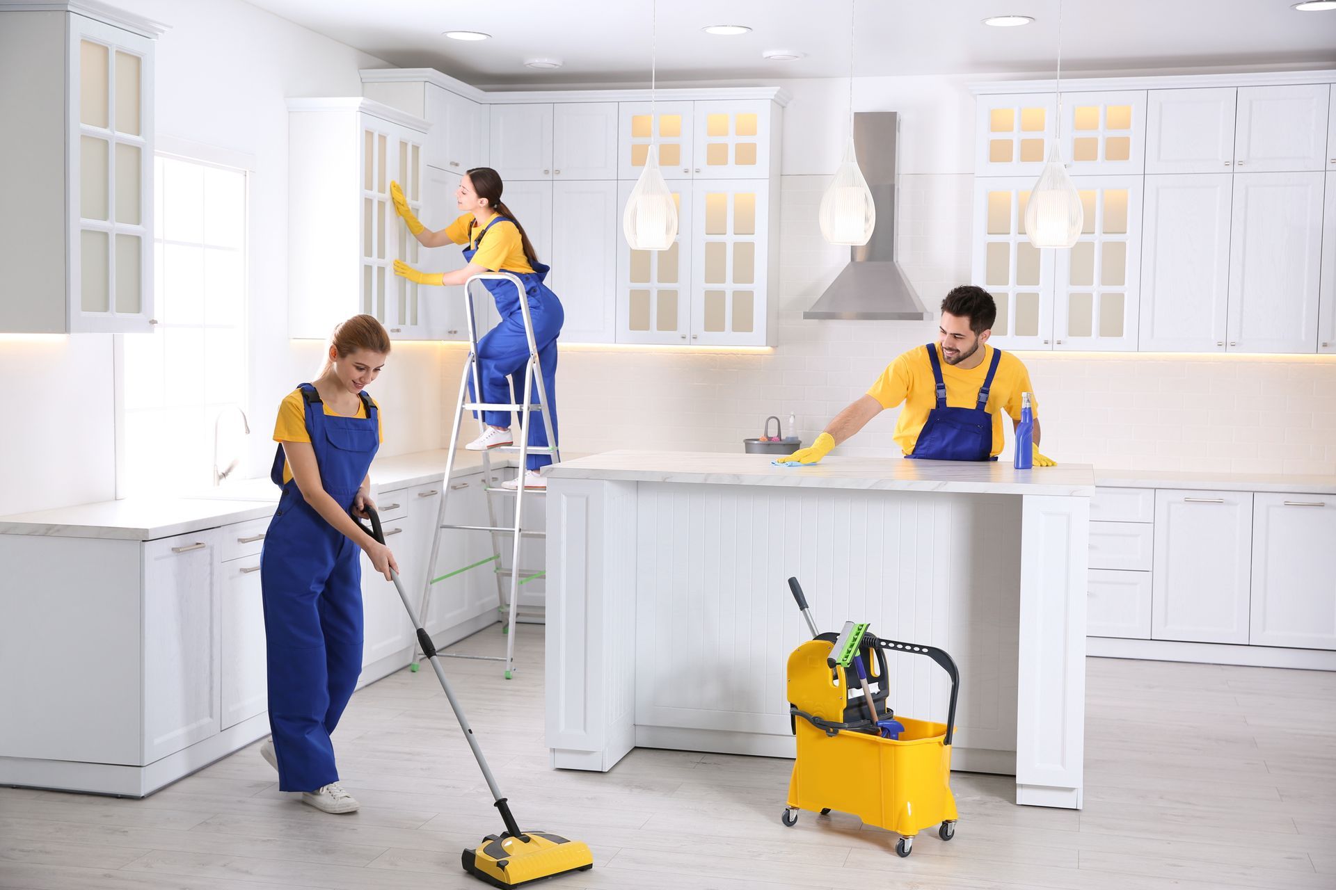 A group of cleaners are cleaning a kitchen.