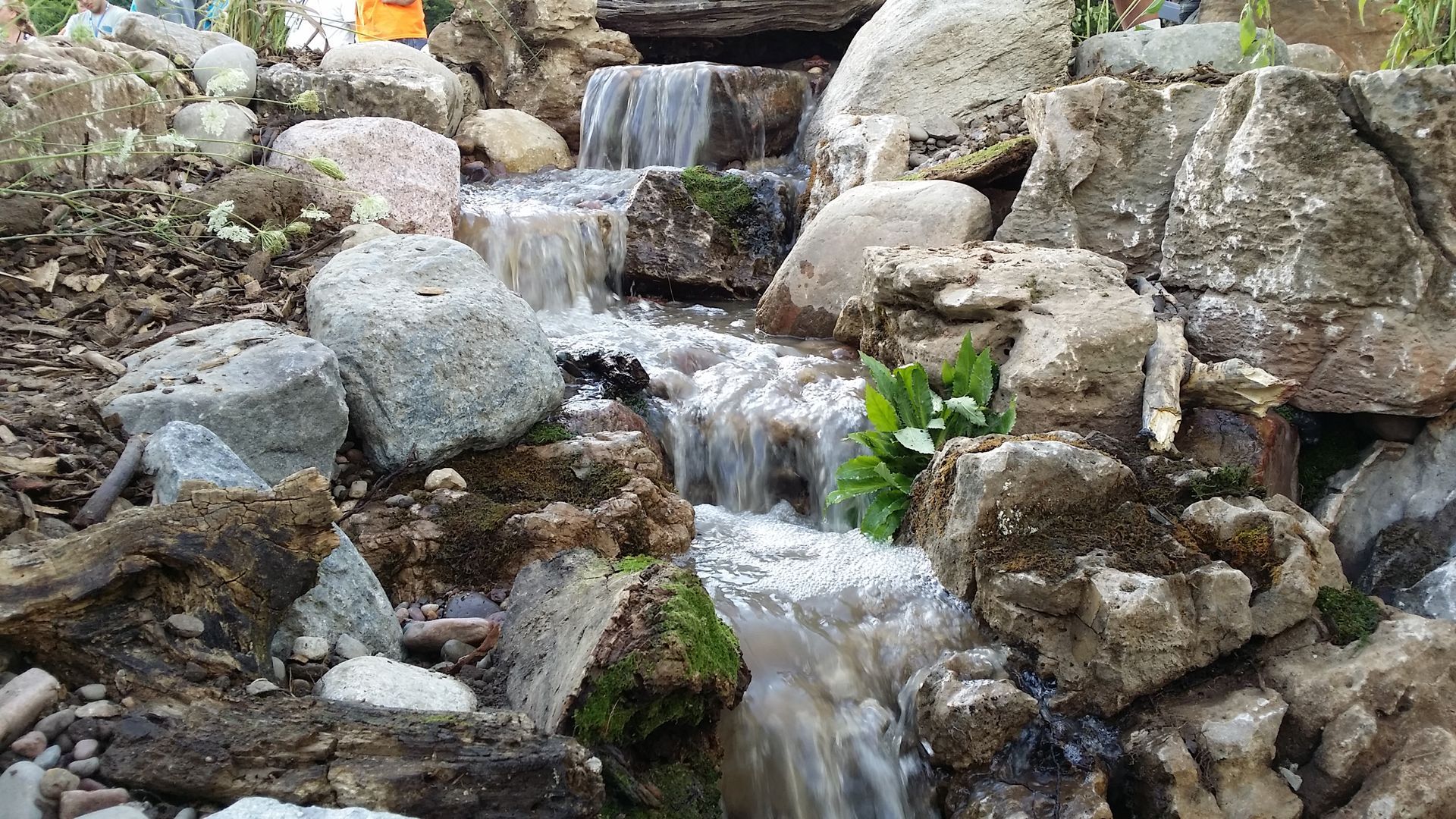 Waterfall cascading over mossy rocks in a natural setting.