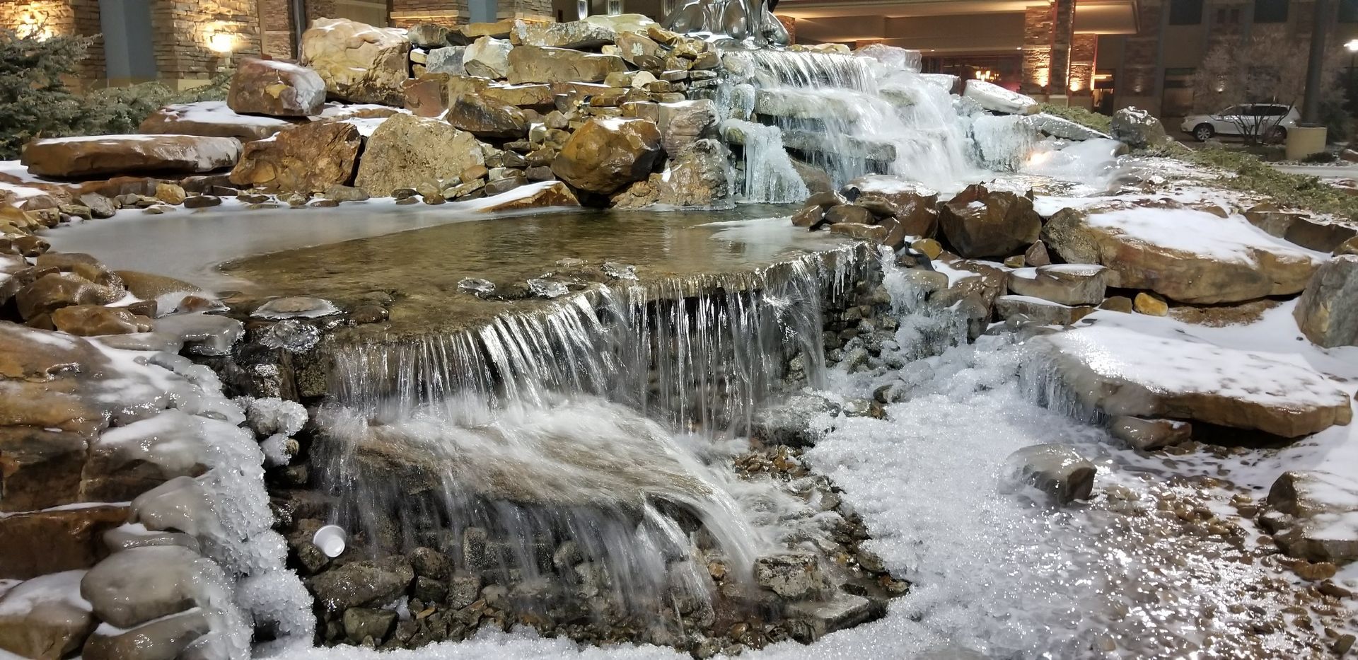 Frozen waterfall cascading over rocks; winter scene.