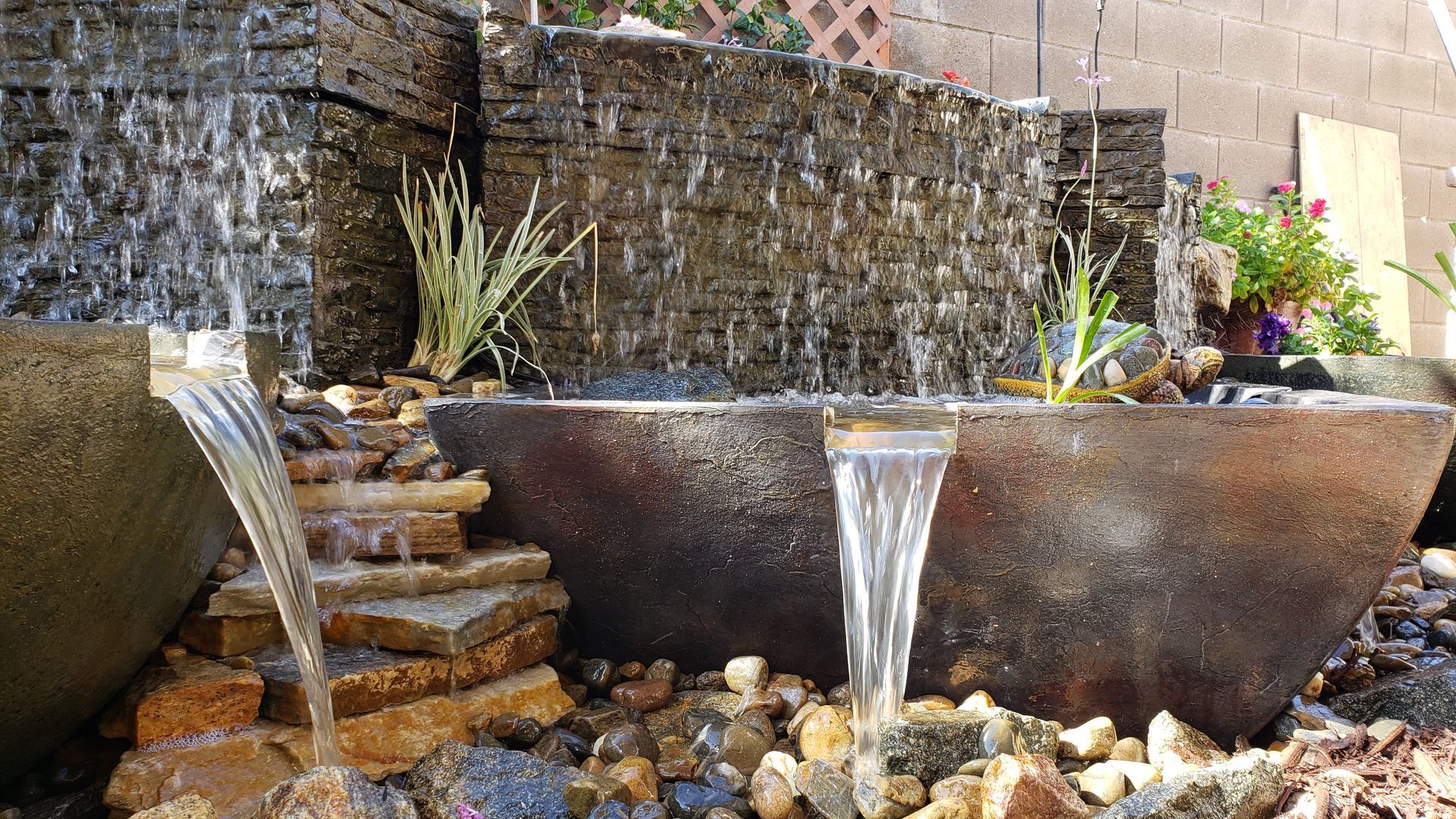 Water fountain with stone tiers and bowls, water flowing.