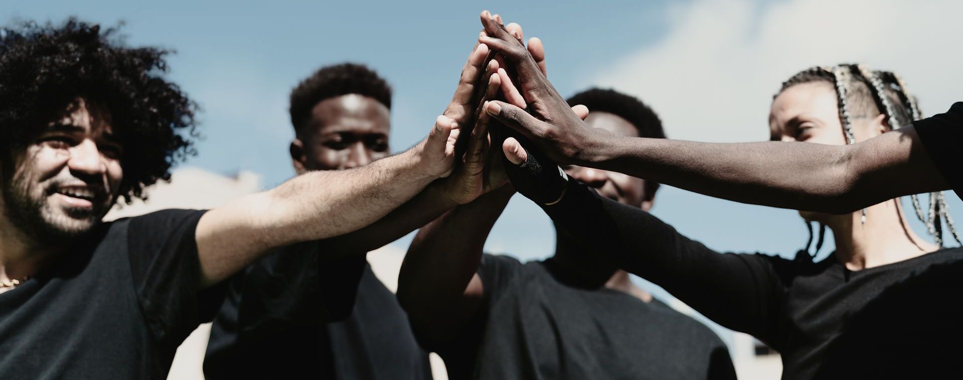 A group of young men are giving each other a high five.