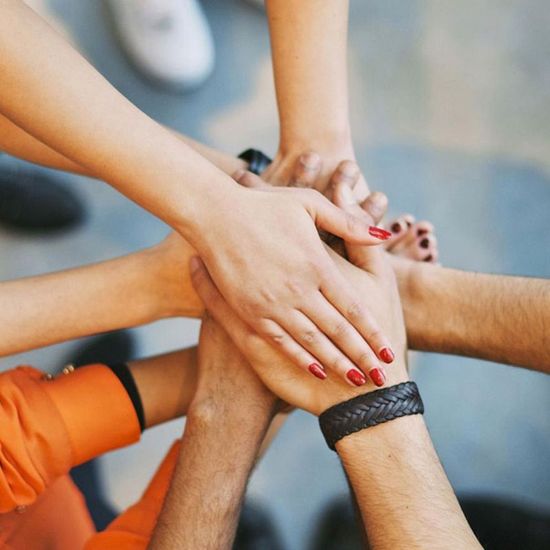 OFCP Support Programs Group of hands coming together like a huddle to depict how the OFCP programs support members of the community with Cerebral Palsy