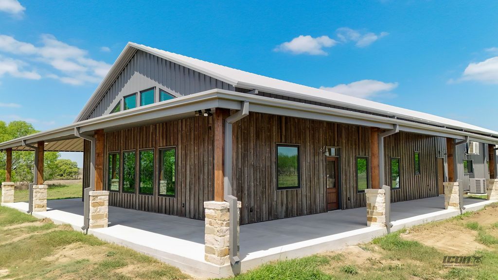 Rustic wooden building with a gabled roof and covered porch under a blue sky