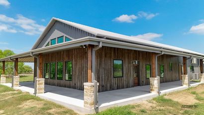 Rustic wooden building with a gabled roof and covered porch under a blue sky