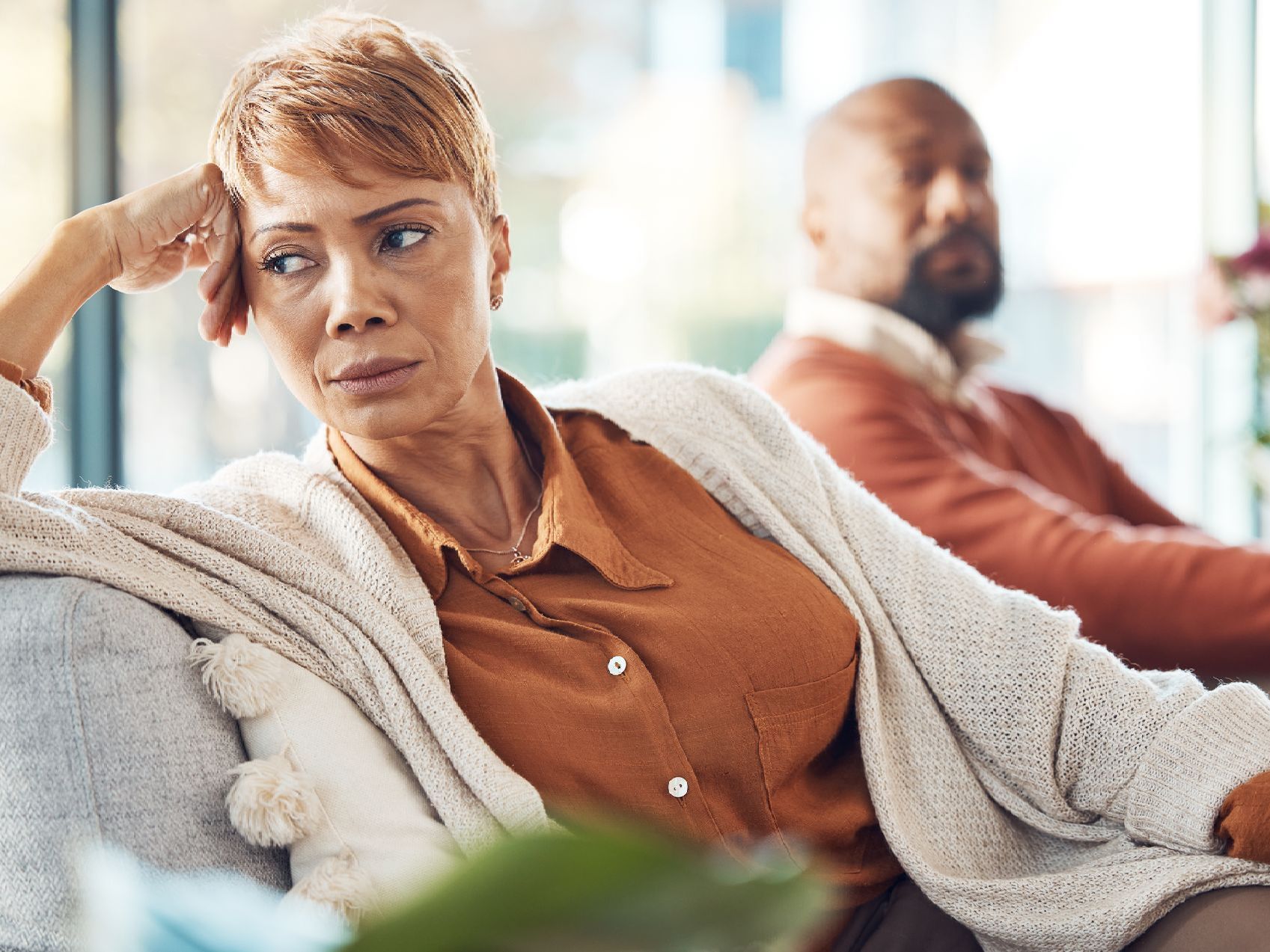 A woman is sitting on a couch next to a man.