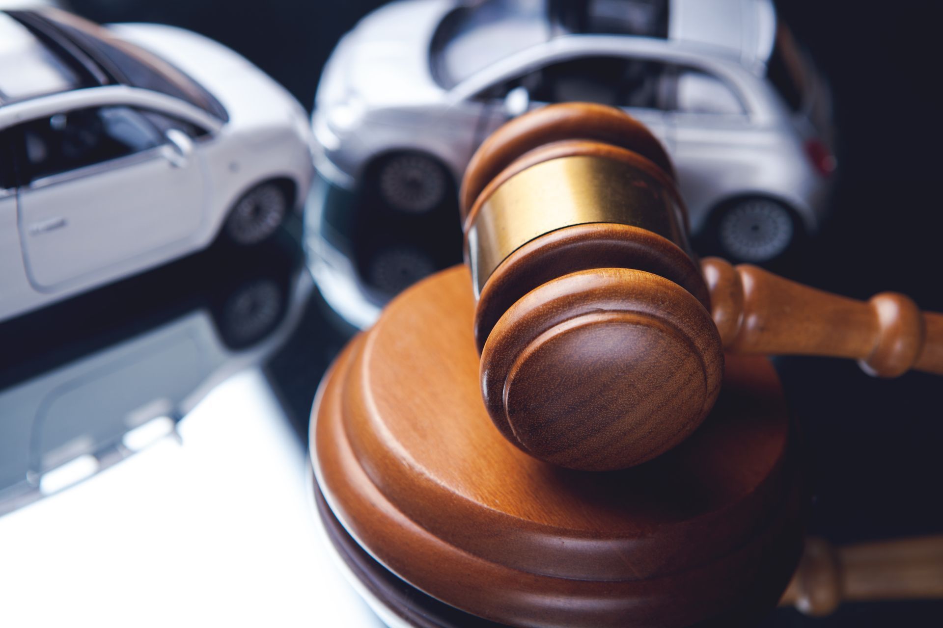 A judge's gavel with two damaged cars in the background. A judge's gavel with two damaged cars in the background.