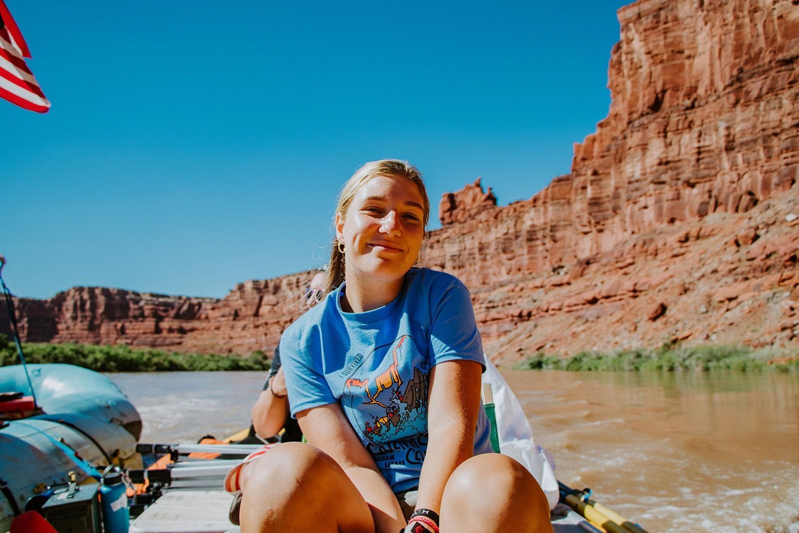 A woman is sitting on a raft in the middle of a river.