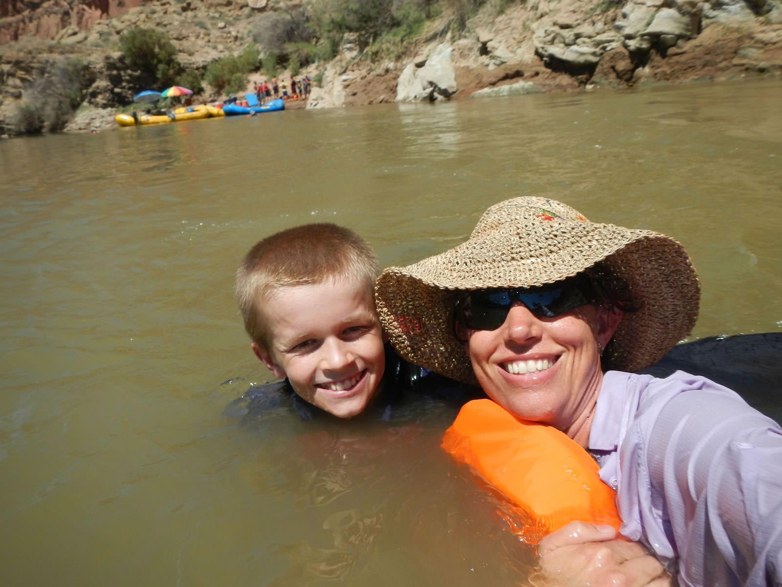 A woman and a boy are posing for a picture in the water.