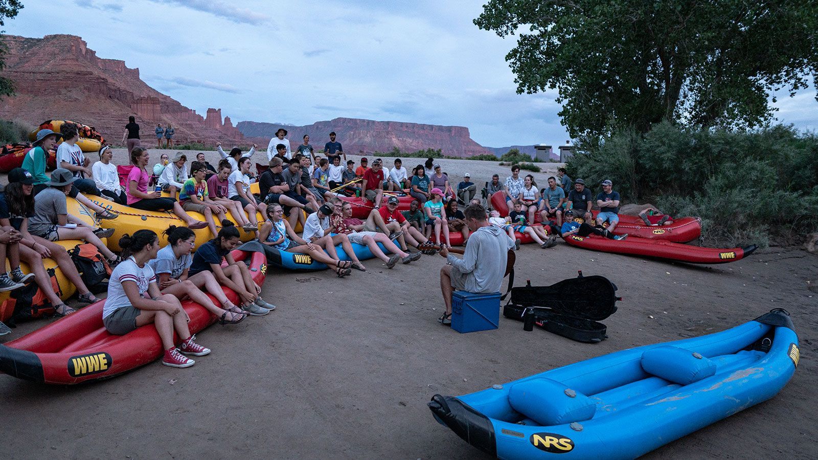A group of people are rafting down a river in a red raft