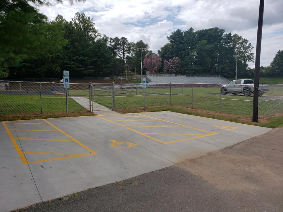 chain link fence lining football field and parking lot