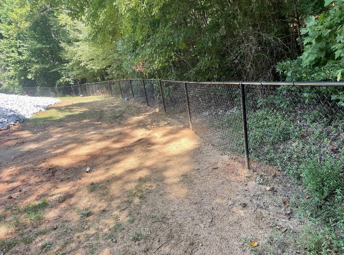 Vinyl-coated chain link fencing along tree line