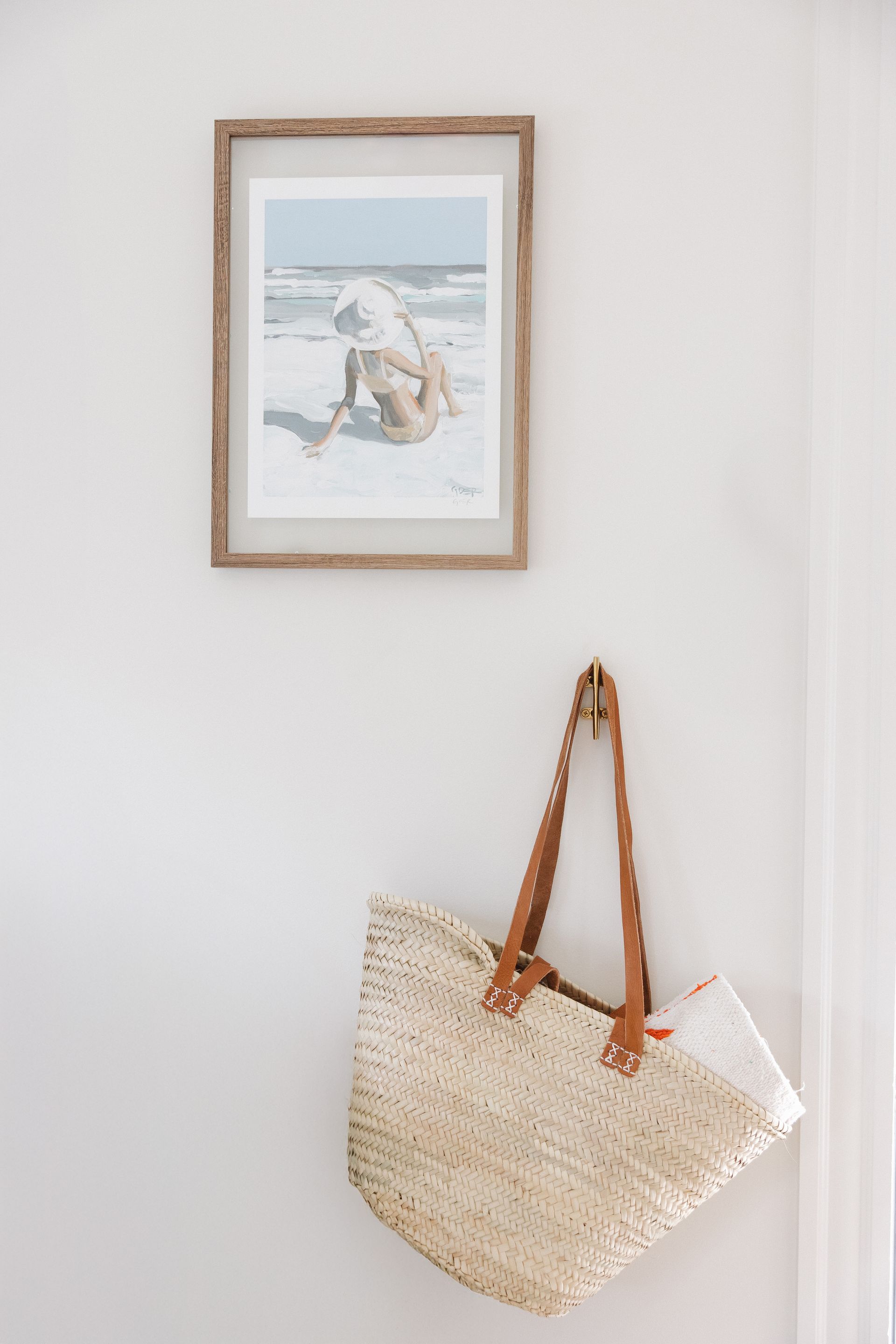 A picture is hanging on a wall next to a plant.