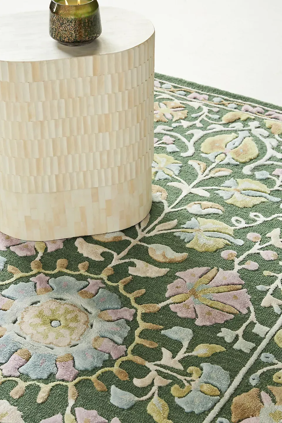 A rug with a floral pattern is on the floor next to a table.