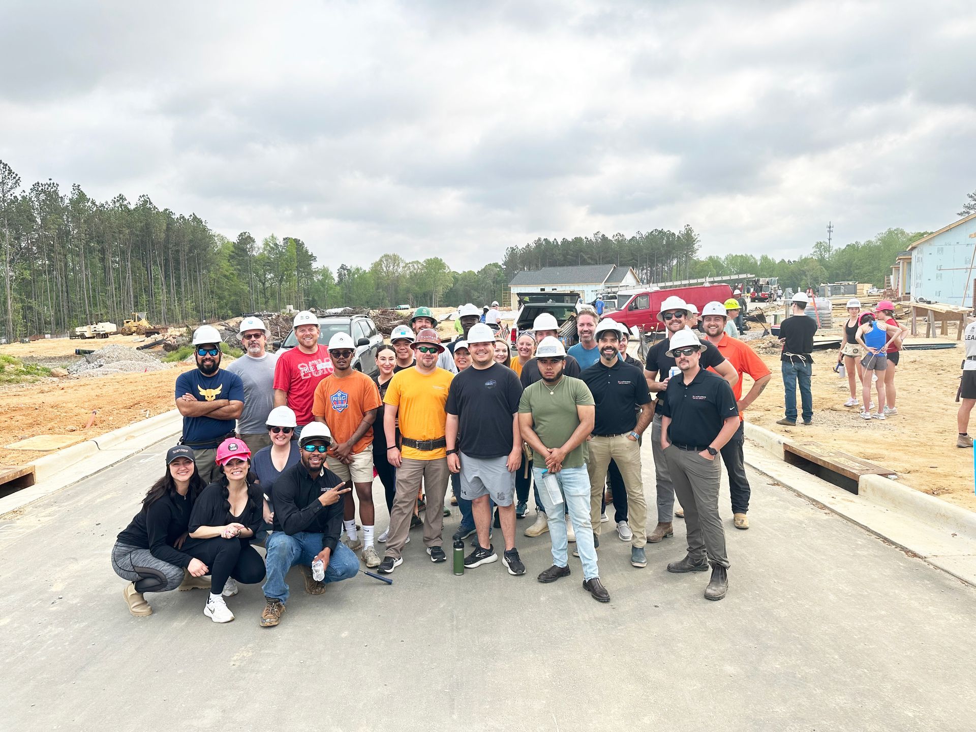 A group of construction workers are posing for a picture on a construction site.