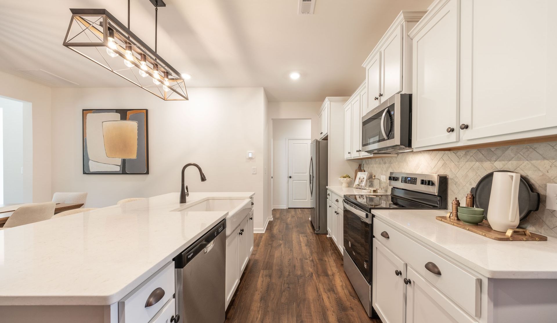 Bright kitchen with white cabinets, stainless steel appliances, and a large island.