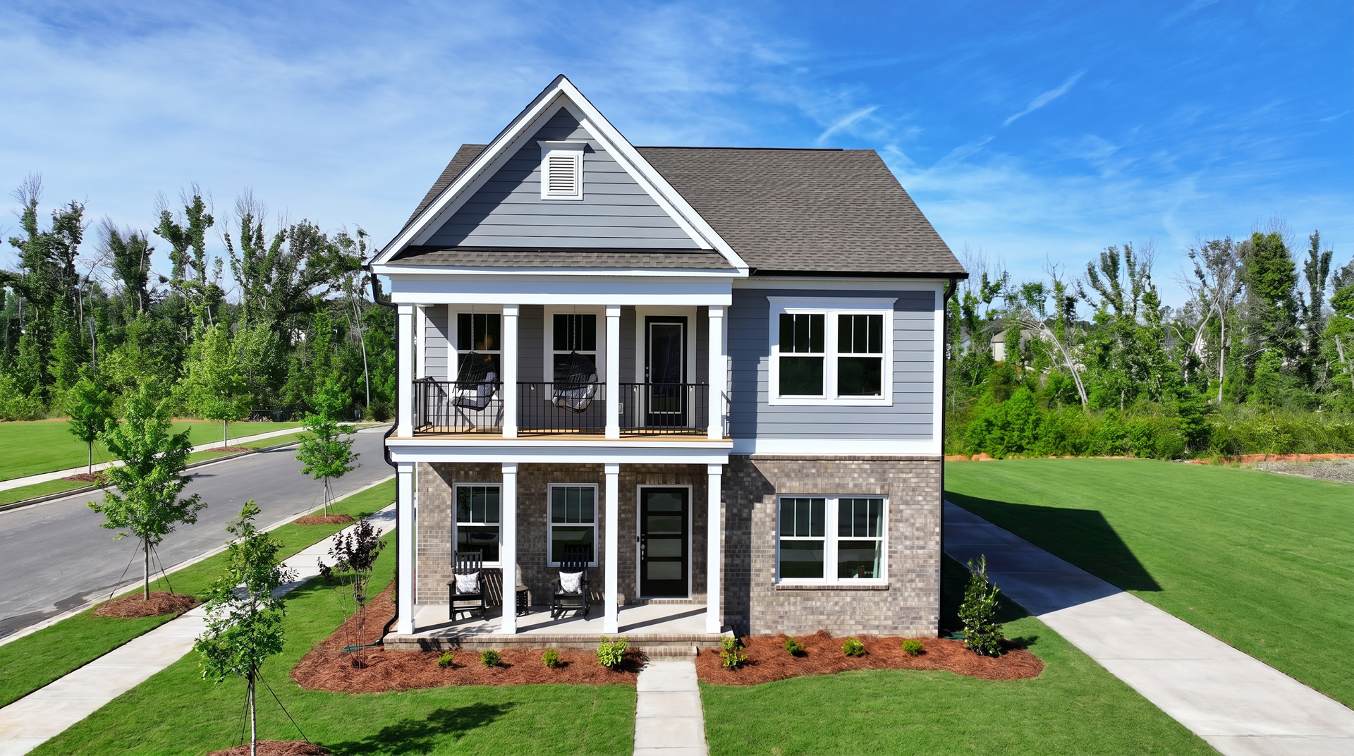 Row of modern houses in light blue, gray, and white against a bright blue sky.