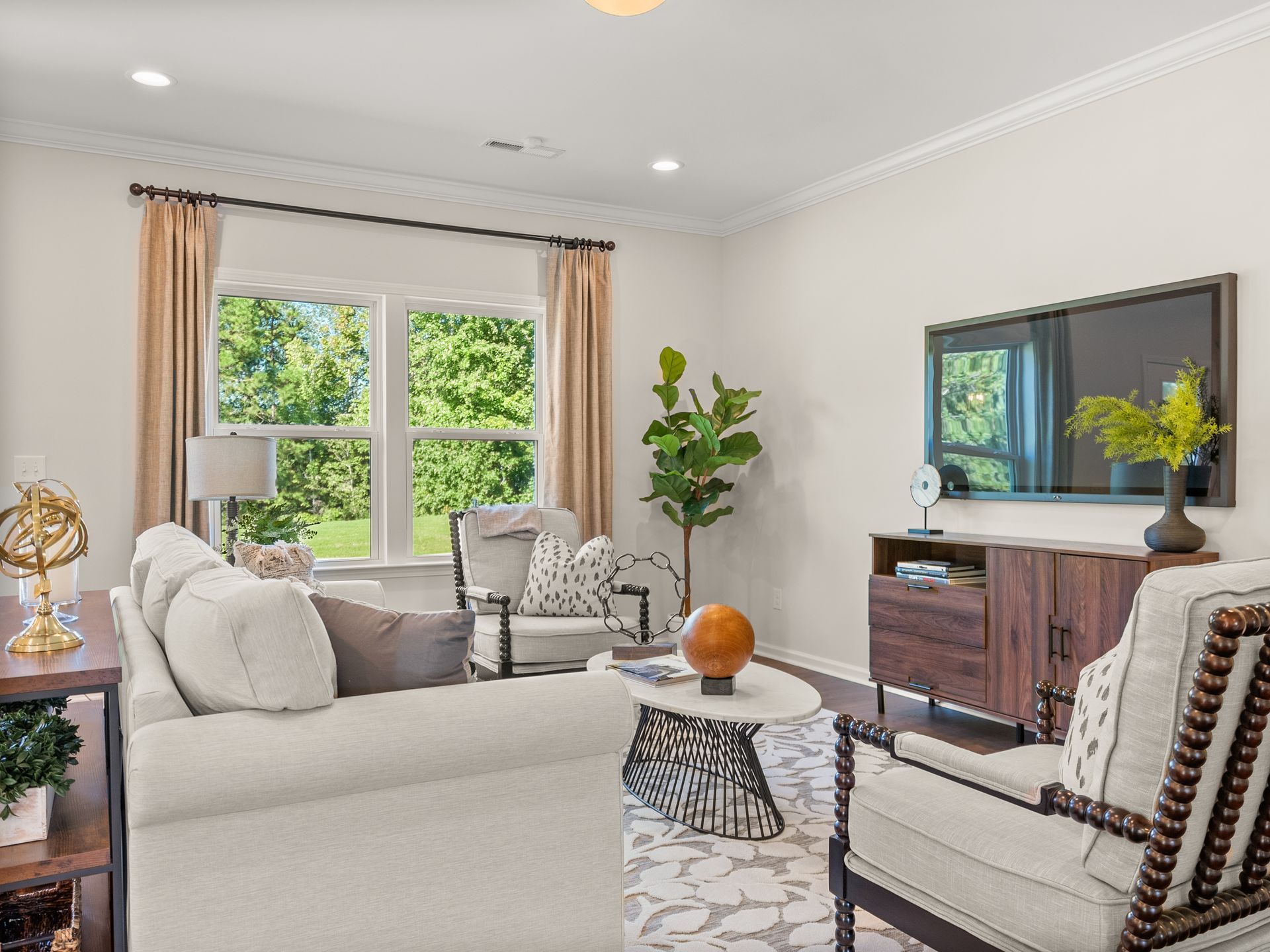 A living room with a couch , chairs , table and television.