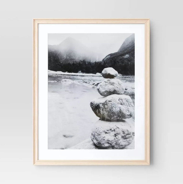 A black and white photo of rocks stacked on top of each other in the snow.