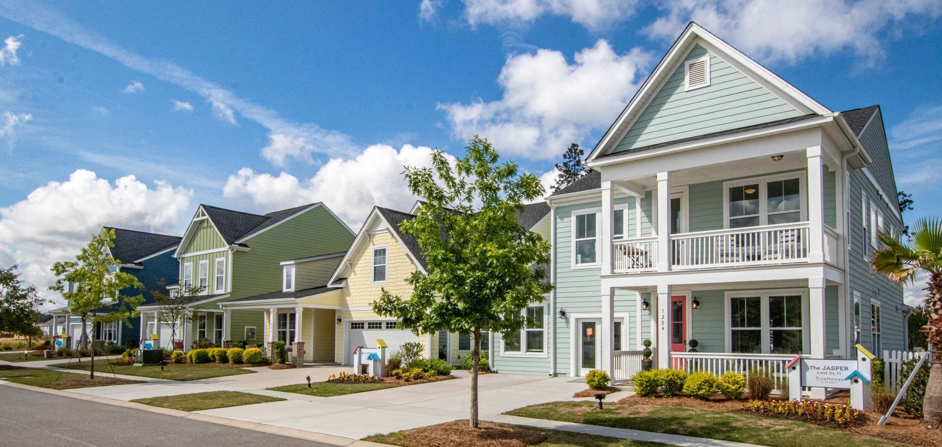 Row of colorful houses with front porches on a sunny day.