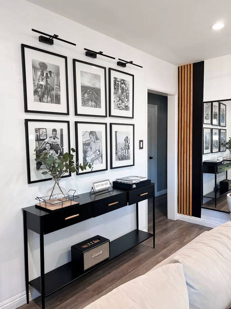 A living room with a couch , table , and pictures on the wall.