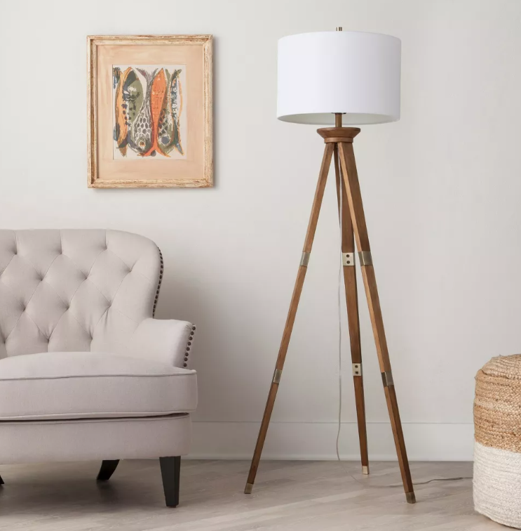 A living room with a couch a lamp and a picture on the wall