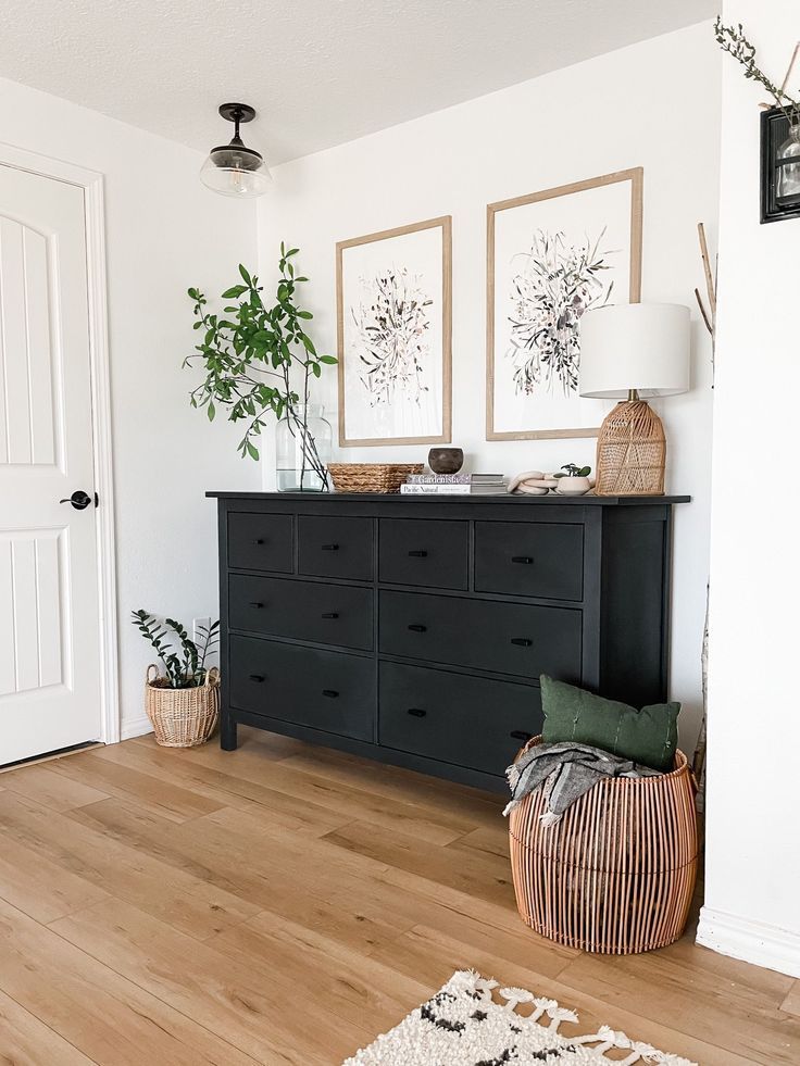 There is a black dresser in the middle of the room.